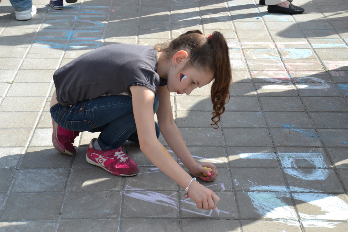 девочка рисует мелом на асфальте 