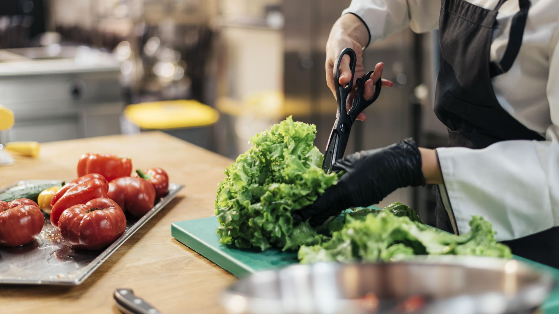 female chef with glove chopping salad